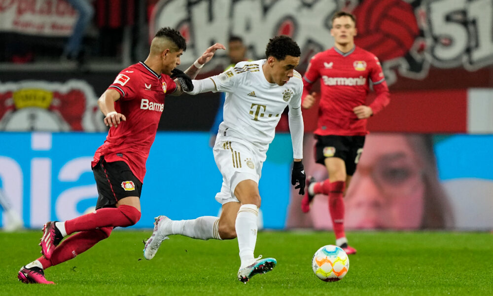 FILE - Bayern's Jamal Musiala, center, and Leverkusen's Piero Hincapie, left, challenge for the ball during the German Bundesliga soccer match between Bayer Leverkusen and Bayern Munich in Leverkusen, Germany, Sunday, March 19, 2023. Bayern Munich hosts Bayer Leverkusen when the Bundesliga returns from the international break with its biggest game of the season so far. Something will need to give on Friday between the only two teams remaining with perfect records. Leverkusen has racked up 11 goals in three wins from three games and leads on goal difference from Bayern. (AP Photo/Martin Meissner, File)