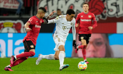 FILE - Bayern's Jamal Musiala, center, and Leverkusen's Piero Hincapie, left, challenge for the ball during the German Bundesliga soccer match between Bayer Leverkusen and Bayern Munich in Leverkusen, Germany, Sunday, March 19, 2023. Bayern Munich hosts Bayer Leverkusen when the Bundesliga returns from the international break with its biggest game of the season so far. Something will need to give on Friday between the only two teams remaining with perfect records. Leverkusen has racked up 11 goals in three wins from three games and leads on goal difference from Bayern. (AP Photo/Martin Meissner, File)