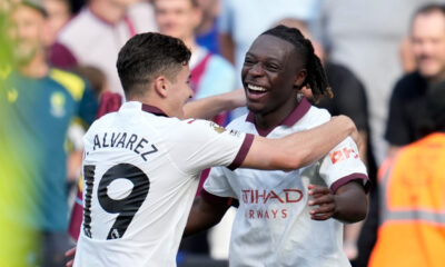 Manchester City's Jeremy Doku celebrates with Julian Alvarez, left, after scoring his side's first goal during the English Premier League soccer match between West Ham United and Manchester City at London stadium in London, Saturday, Sept. 16, 2023. (AP Photo/Kin Cheung)