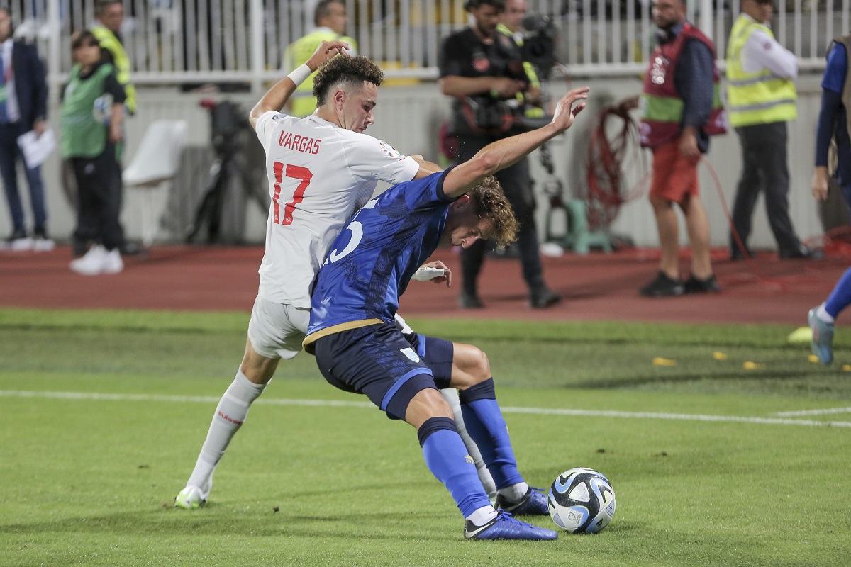 Kosovo's Mergim Vojvoda, right, fights for the ball with Switzerland's Ruben Vargas during the Euro 2024 group I qualifying soccer match between Kosovo and Switzerland at the Fadil Vokrri stadium in Pristina, Kosovo, Saturday, Sept. 9, 2023. (AP Photo/Visar Kryeziu)