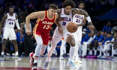 Atlanta Hawks' Bogdan Bogdanovic, left, and Philadelphia 76ers' Kelly Oubre Jr., right, chase after the ball during the second half of a preseason NBA basketball game, Friday, Oct. 20, 2023, in Philadelphia. (AP Photo/Chris Szagola)