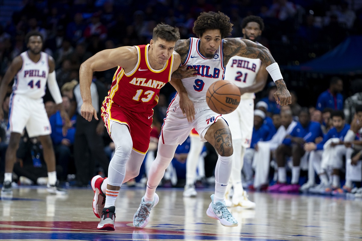 Atlanta Hawks' Bogdan Bogdanovic, left, and Philadelphia 76ers' Kelly Oubre Jr., right, chase after the ball during the second half of a preseason NBA basketball game, Friday, Oct. 20, 2023, in Philadelphia. (AP Photo/Chris Szagola)
