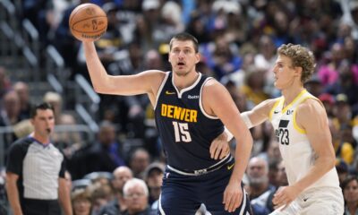 Denver Nuggets center Nikola Jokic, left, fields a pass as Utah Jazz forward Lauri Markkanen defends in the second half of an NBA basketball game, Monday, Oct. 30, 2023, in Denver. (AP Photo/David Zalubowski)