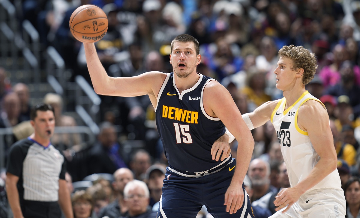 Denver Nuggets center Nikola Jokic, left, fields a pass as Utah Jazz forward Lauri Markkanen defends in the second half of an NBA basketball game, Monday, Oct. 30, 2023, in Denver. (AP Photo/David Zalubowski)