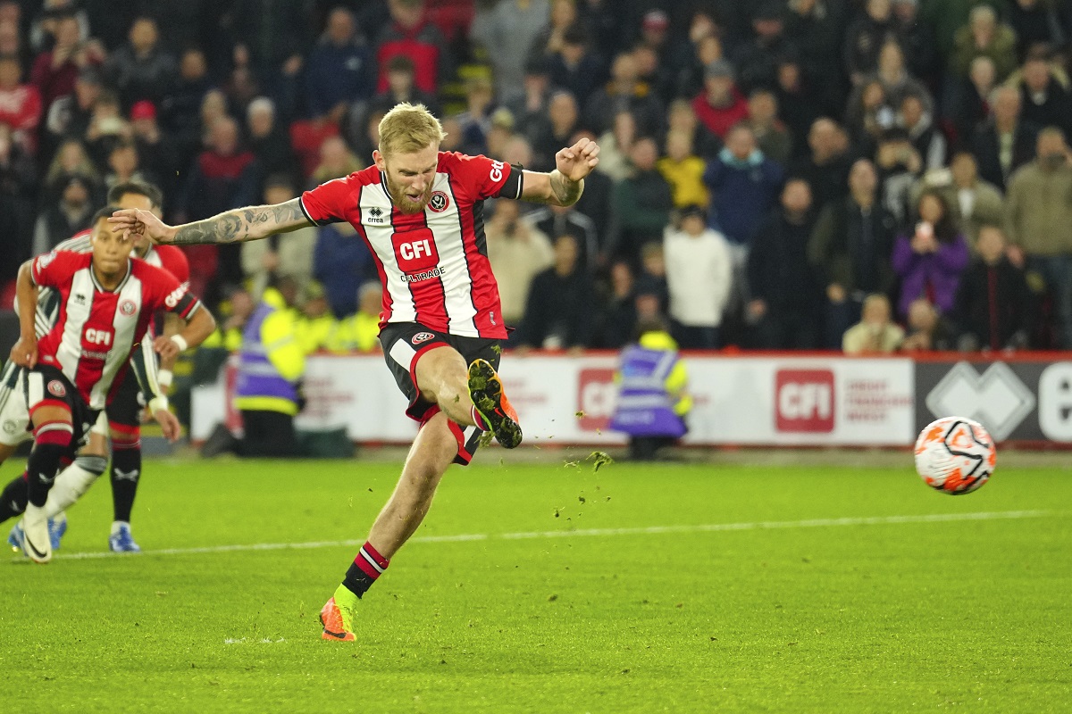 Sheffield United's Oli McBurnie shoots to score from the penalty spot during the English Premier League soccer match between Sheffield United and Manchester United at Bramall Lane in Sheffield, England, Saturday, Oct. 21, 2023. (AP Photo/Jon Super)