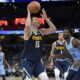 Denver Nuggets center Nikola Jokic (15) looks to shoot against Memphis Grizzlies forward Jaren Jackson Jr. (13) during the second half of an NBA basketball game Friday, Oct. 27, 2023, in Memphis, Tenn. (AP Photo/Brandon Dill)