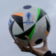 A woman shows the UEFA Euro 2024 Ball during a presentation in Berlin, Germany, Wednesday, Nov. 15, 2023. The ball is named 'Fussballliebe' - 'Footbal Love' or 'Soccer Love'. (AP Photo/Markus Schreiber)