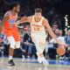 Atlanta Hawks guard Bogdan Bogdanovic (13) pushes past Oklahoma City Thunder guard Cason Wallace, left, in the first half of an NBA basketball game, Monday, Nov. 6, 2023, in Oklahoma City. (AP Photo/Kyle Phillips)