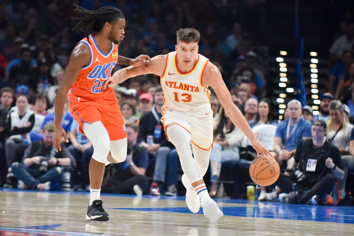 Atlanta Hawks guard Bogdan Bogdanovic (13) pushes past Oklahoma City Thunder guard Cason Wallace, left, in the first half of an NBA basketball game, Monday, Nov. 6, 2023, in Oklahoma City. (AP Photo/Kyle Phillips)