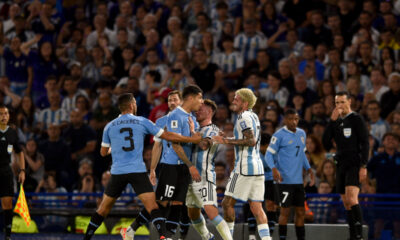 Argentina's Lionel Messi holds back Uruguay's Mathias Olivera, as he argues with Argentina's Rodrigo De Paul, during a qualifying soccer match for the FIFA World Cup 2026 at La Bombonera stadium in Buenos Aires, Argentina, Thursday, Nov. 16, 2023. (AP Photo/Gustavo Garello)