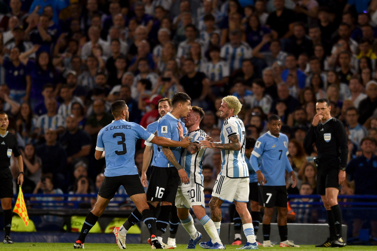 Argentina's Lionel Messi holds back Uruguay's Mathias Olivera, as he argues with Argentina's Rodrigo De Paul, during a qualifying soccer match for the FIFA World Cup 2026 at La Bombonera stadium in Buenos Aires, Argentina, Thursday, Nov. 16, 2023. (AP Photo/Gustavo Garello)