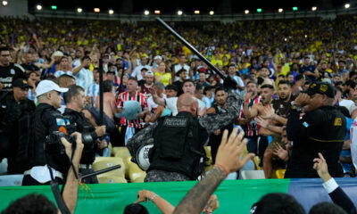 Policemen try to stop a fight between Brazilian and Argentinians fans at the stands prior to a qualifying soccer match for the FIFA World Cup 2026 at Maracana stadium in Rio de Janeiro, Brazil, Tuesday, Nov. 21, 2023.(AP Photo/Silvia Izquierdo)