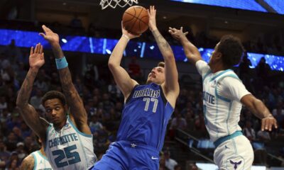Dallas Mavericks guard Luka Doncic (77) shoots against Charlotte Hornets forward P.J. Washington (25) and guard Theo Maledon, right, in the second half of an NBA basketball game Sunday, Nov. 5, 2023, in Dallas. (AP Photo/Richard W. Rodriguez)