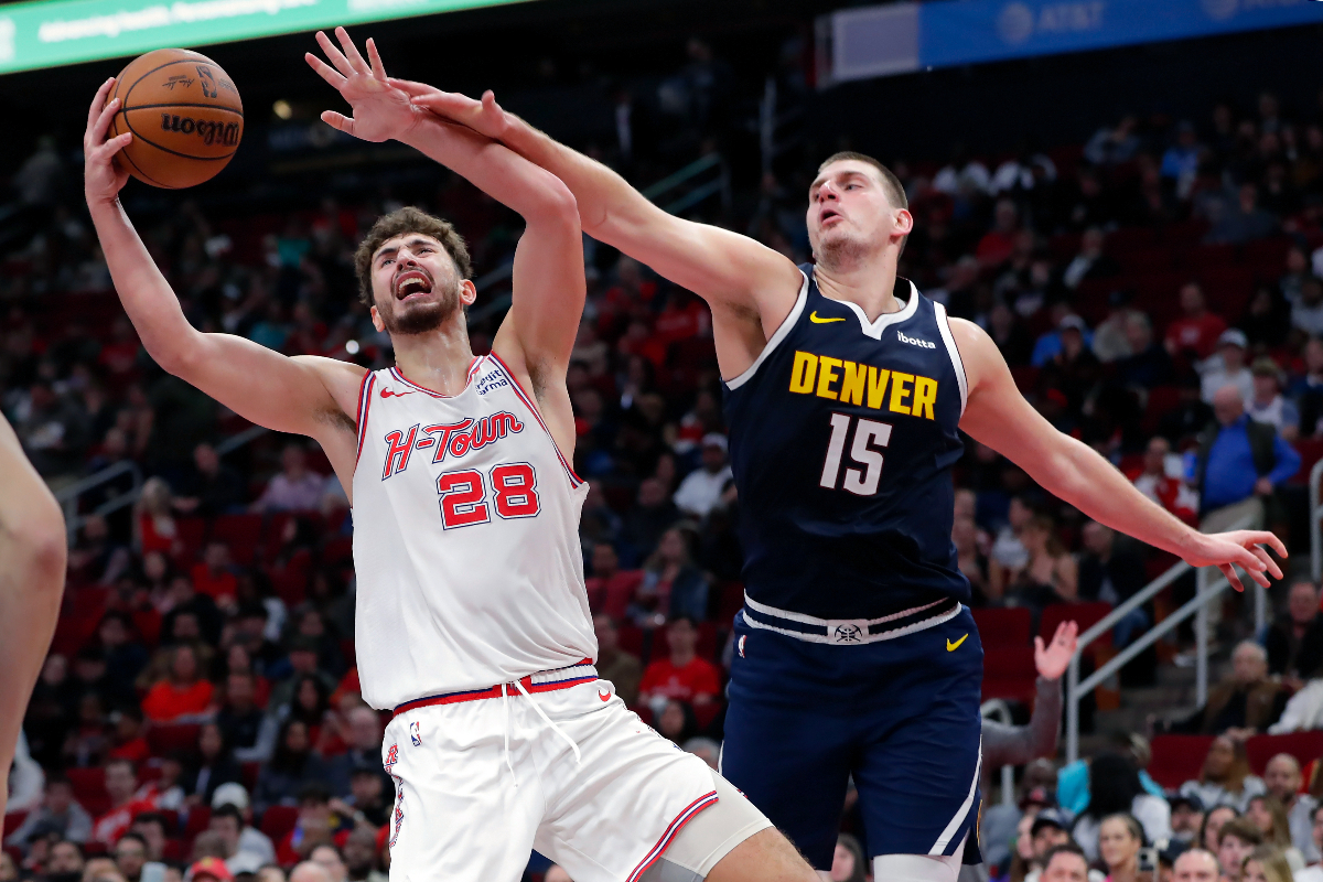 Houston Rockets center Alperen Sengun (28) pulls in a rebound next to Denver Nuggets center Nikola Jokic (15) during the second half of an NBA basketball In-Season Tournament game Friday, Nov. 24, 2023, in Houston. (AP Photo/Michael Wyke)