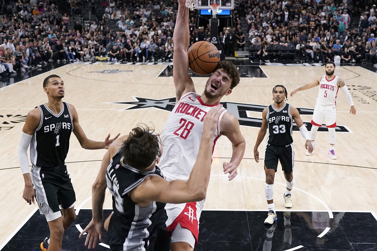 Houston Rockets center Alperen Sengun (28) scores over San Antonio Spurs forward Zach Collins (23) during overtime in an NBA basketball game in San Antonio, Friday, Oct. 27, 2023. (AP Photo/Eric Gay)