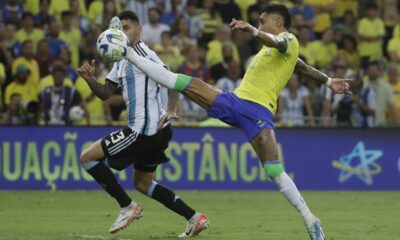 Brazil's Raphinha stretches for a ball challenged by Argentina's Cristian Romero during a qualifying soccer match for the FIFA World Cup 2026 at Maracana stadium in Rio de Janeiro, Brazil, Tuesday, Nov. 21, 2023. (AP Photo/Bruna Prado)