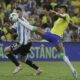 Brazil's Raphinha stretches for a ball challenged by Argentina's Cristian Romero during a qualifying soccer match for the FIFA World Cup 2026 at Maracana stadium in Rio de Janeiro, Brazil, Tuesday, Nov. 21, 2023. (AP Photo/Bruna Prado)