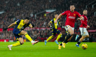 Bournemouth's Dominic Solanke, left, kicks the ball during the English Premier League soccer match between Manchester United and Bournemouth at the Old Trafford stadium in Manchester, England, Saturday, Dec. 9, 2023. (AP Photo/Jon Super)