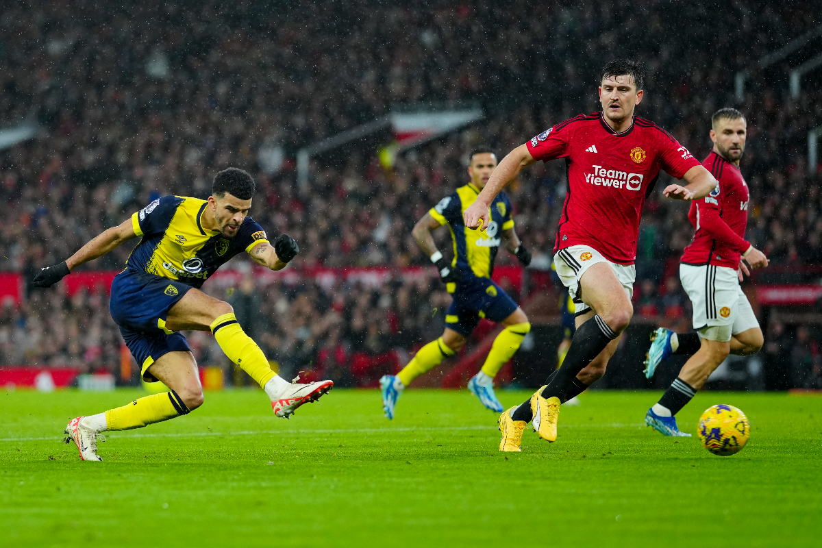 Bournemouth's Dominic Solanke, left, kicks the ball during the English Premier League soccer match between Manchester United and Bournemouth at the Old Trafford stadium in Manchester, England, Saturday, Dec. 9, 2023. (AP Photo/Jon Super)
