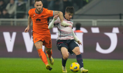 Inter Milan's Marko Arnautovic, left, and Bologna's Tommaso Corazza challenge for the ball during an Italian Cup round of 16 soccer match between Inter Milan and Bologna, at the San Siro stadium in Milan, Italy, Wednesday, Dec. 20, 2023. (AP Photo/Luca Bruno)