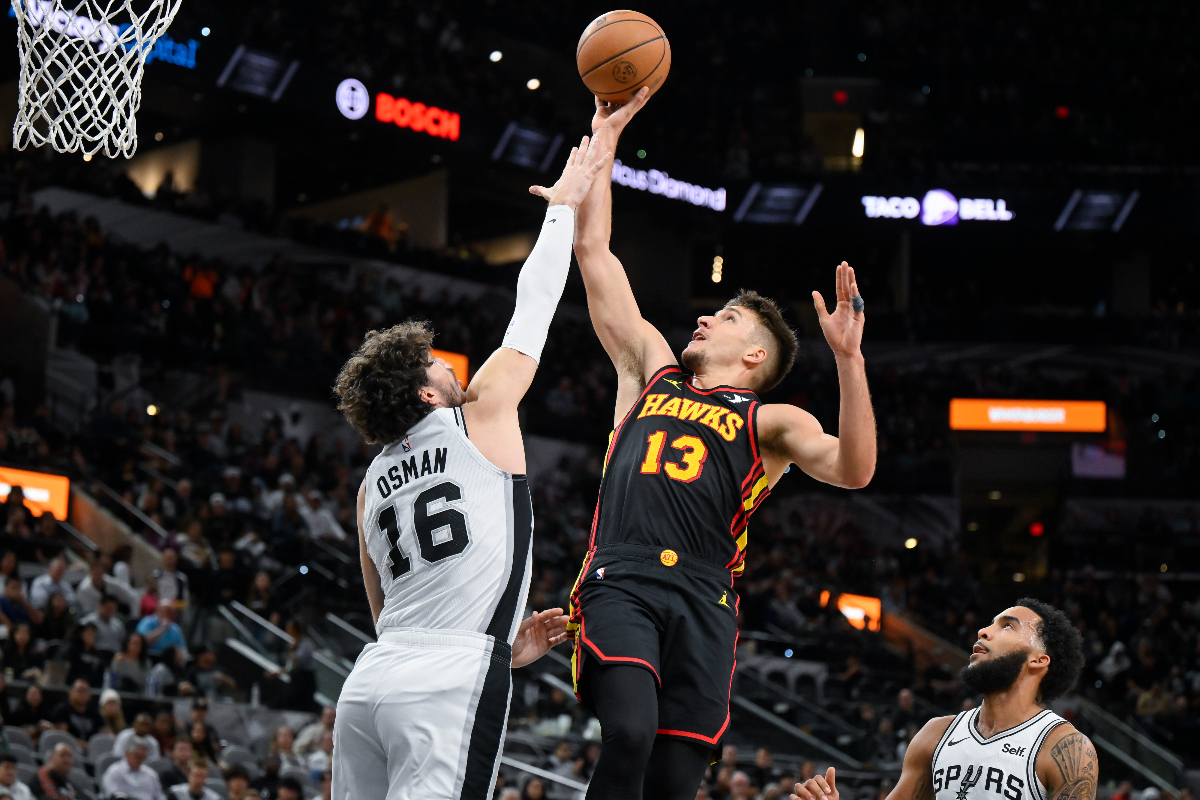 Atlanta Hawks' Bogdan Bogdanovic (13) goes to the basket against San Antonio Spurs' Cedi Osman during the first half of an NBA basketball game Thursday, Nov. 30, 2023, in San Antonio. (AP Photo/Darren Abate)