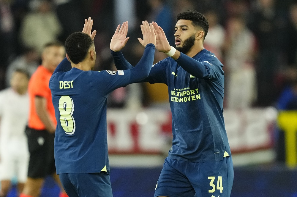 PSV's Ismael Saibari celebrates with his teammate Sergino Dest after scoring his side's first goal during the Champions League Group B soccer match between Sevilla and PSV at the Ramon Sanchez-Pizjuan stadium in Seville, Spain, Wednesday, Nov.29, 2023. (AP Photo/Jose Breton)