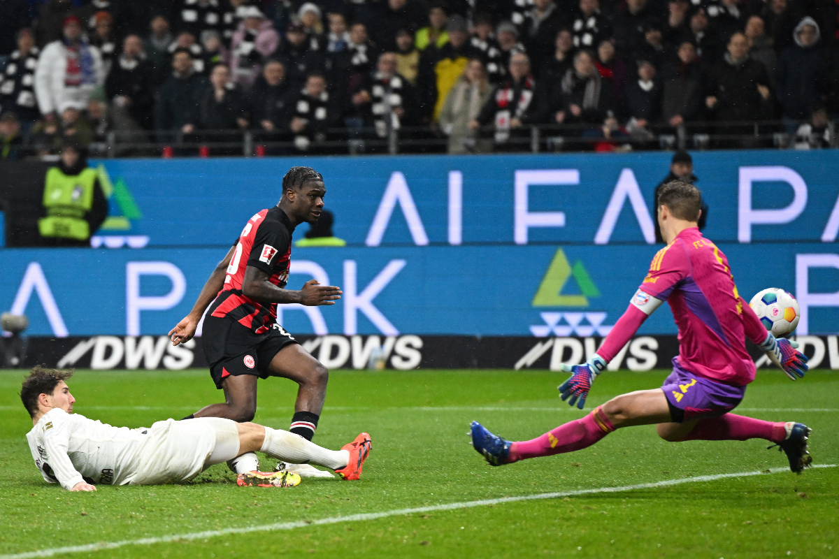 Frankfurt's Eric Junior Dina Ebimbe, center, scores his side's fourth goal of the game past Munich goalkeeper Manuel Neuer during the German Bundesliga soccer match between Eintracht Frankfurt and Bayern Munich at Deutsche Bank Park in Frankfurt, Germany, Saturday, Dec. 9, 2023. (Arne Dedert/dpa via AP)