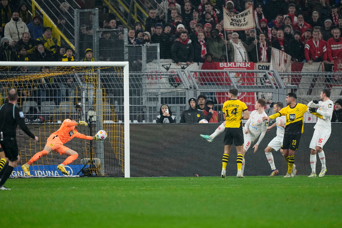 Mainz's Sepp van den Berg, fourth right, scores his sides first goal during the German Bundesliga soccer match between Borussia Dortmund and 1. FSV Mainz 05 at the Signal-Iduna Park in Dortmund, Germany, Tuesday, Dec. 19, 2023. (AP Photo/Martin Meissner)