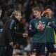 Arsenal's Martin Odegaard, second right, speaks to members of team support staff during the English Premier League soccer match between Arsenal and Fulham at Craven Cottage stadium in London, Sunday, Dec. 31, 2023. (AP Photo/Alastair Grant)