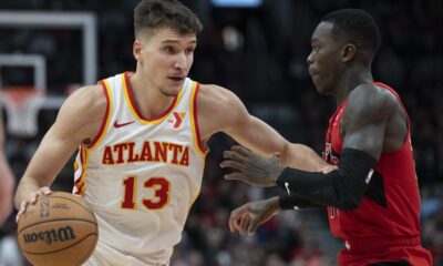 Atlanta Hawks Bogdan Bogdanović (13) drives past Toronto Raptors guard Dennis Schröder during the second half of an NBA basketball game in Toronto, Wednesday, Dec. 13, 2023. (Frank Gunn/The Canadian Press via AP)
