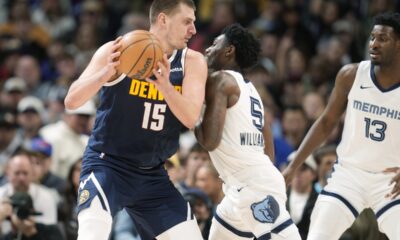 Denver Nuggets center Nikola Jokic, left, looks to drive to the basket as Memphis Grizzlies guard Vince Williams Jr., center, and forward Jaren Jackson Jr., right, defend in the second half of an NBA basketball game Thursday, Dec. 28, 2023, in Denver. (AP Photo/David Zalubowski)