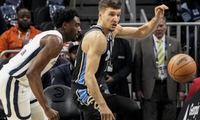 Atlanta Hawks guard Bogdan Bogdanovic (13) and Memphis Grizzlies guard Vince Williams Jr. (5) vie for a loose ball during the first half of an NBA basketball game, Saturday, Dec. 23, 2023, in Atlanta. (AP Photo/Mike Stewart)