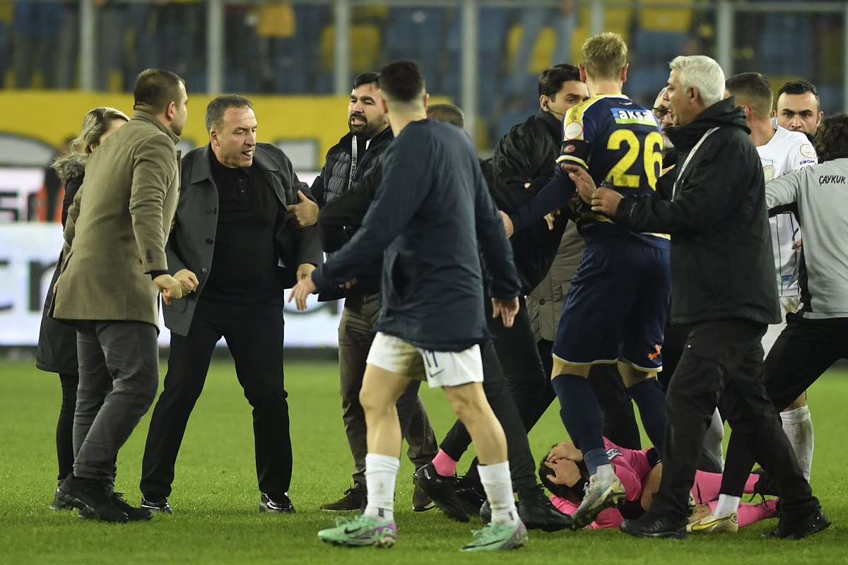 Referee Halil Umut Meler is seen lying on the ground, right, after being punched by MKE Ankaragucu president Faruk Koca, second from left, at the end of the Turkish Super Lig soccer match between MKE Ankaragucu and Caykur Rizespor in Ankara, Monday, Dec. 11, 2023. The Turkish Football Federation has suspended all league games in the country after a club president punched the referee in the face at the end of a top-flight match. Koca was arrested Tuesday, Dec. 12, 2023, along with two other people on charges of injuring a public official following questioning by prosecutors. (Abdurrahman Antakyali/Depo Photos via AP)