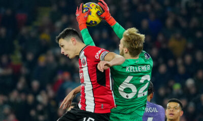 Liverpool's goalkeeper Caoimhin Kelleher, right, and Sheffield United's Anel Ahmedhodzic jump for the ball during the English Premier League soccer match between Sheffield United and Liverpool at Bramall Lane in Sheffield, England, Wednesday, Dec. 6, 2023. (AP Photo/Jon Super)