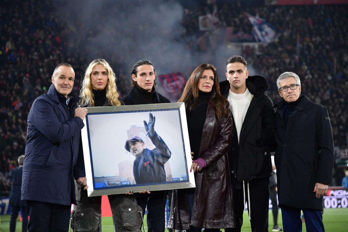 Family members hold a photo in remembrance of the one year anniversary of the death of Sinisa Mihajlovic, ahead of the Italian Serie A soccer match between Bolgna and Roma, at Renato Dall'Ara Stadium, in Bologna, Italy, Sunday, Dec. 17, 2023. (Massimo Paolone /LaPresse via AP)
