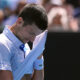 Novak Djokovic of Serbia wipes the sweat from his face during his semifinal against Jannik Sinner of Italy at the Australian Open tennis championships at Melbourne Park, Melbourne, Australia, Friday, Jan. 26, 2024. (AP Photo/Andy Wong)