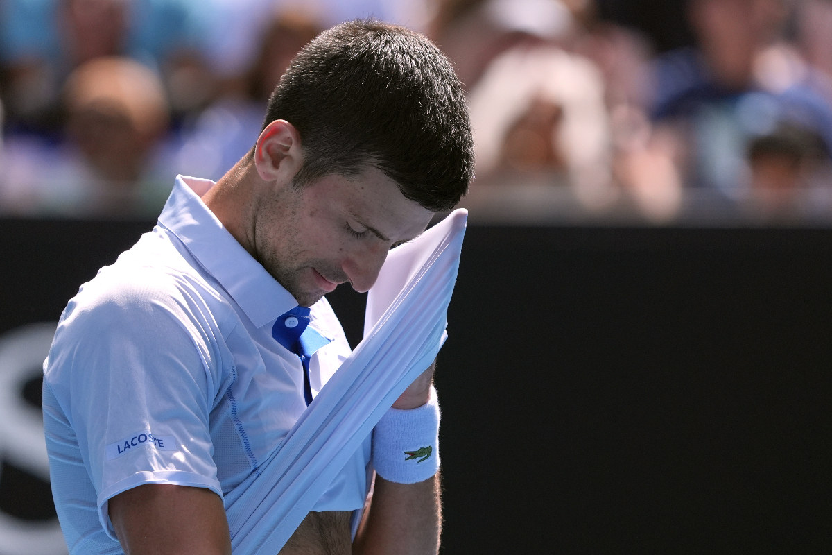 Novak Djokovic of Serbia wipes the sweat from his face during his semifinal against Jannik Sinner of Italy at the Australian Open tennis championships at Melbourne Park, Melbourne, Australia, Friday, Jan. 26, 2024. (AP Photo/Andy Wong)