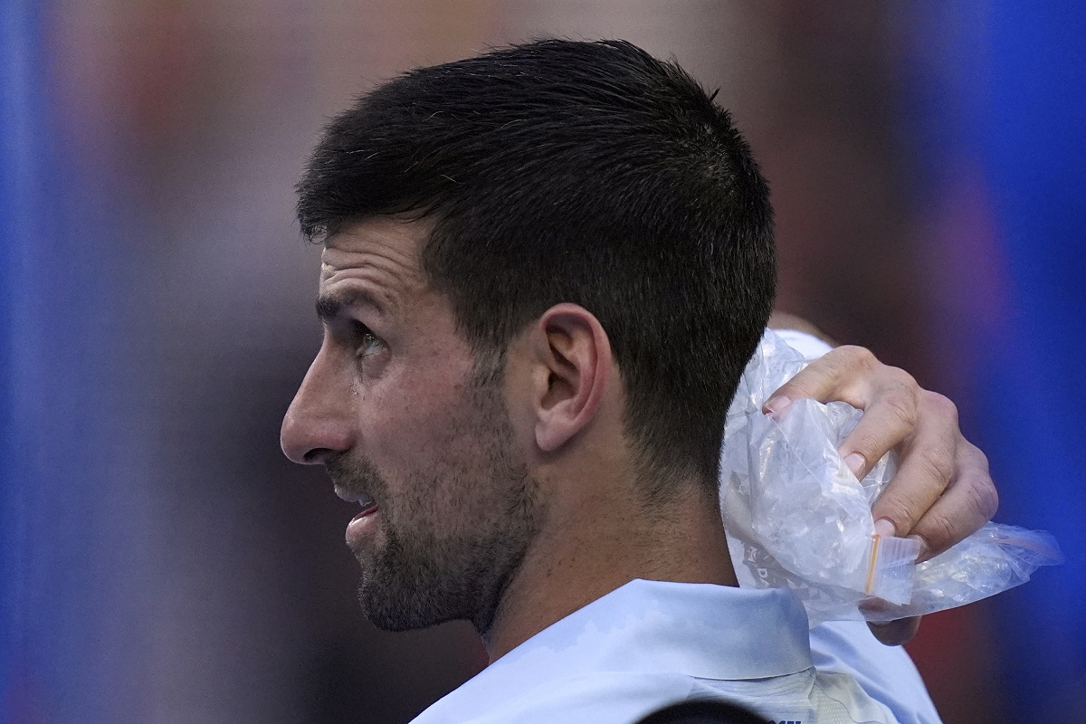 Novak Djokovic of Serbia places a bag of ice on his head during a break in his quarterfinal against Taylor Fritz of the U.S. at the Australian Open tennis championships at Melbourne Park, Melbourne, Australia, Tuesday, Jan. 23, 2024. (AP Photo/Andy Wong)