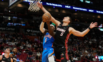 Oklahoma City Thunder guard Luguentz Dort (5) drives to the basket as Miami Heat forward Nikola Jovic (5) defends during the first half of an NBA basketball game, Wednesday, Jan. 10, 2024, in Miami. (AP Photo/Marta Lavandier