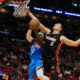 Oklahoma City Thunder guard Luguentz Dort (5) drives to the basket as Miami Heat forward Nikola Jovic (5) defends during the first half of an NBA basketball game, Wednesday, Jan. 10, 2024, in Miami. (AP Photo/Marta Lavandier