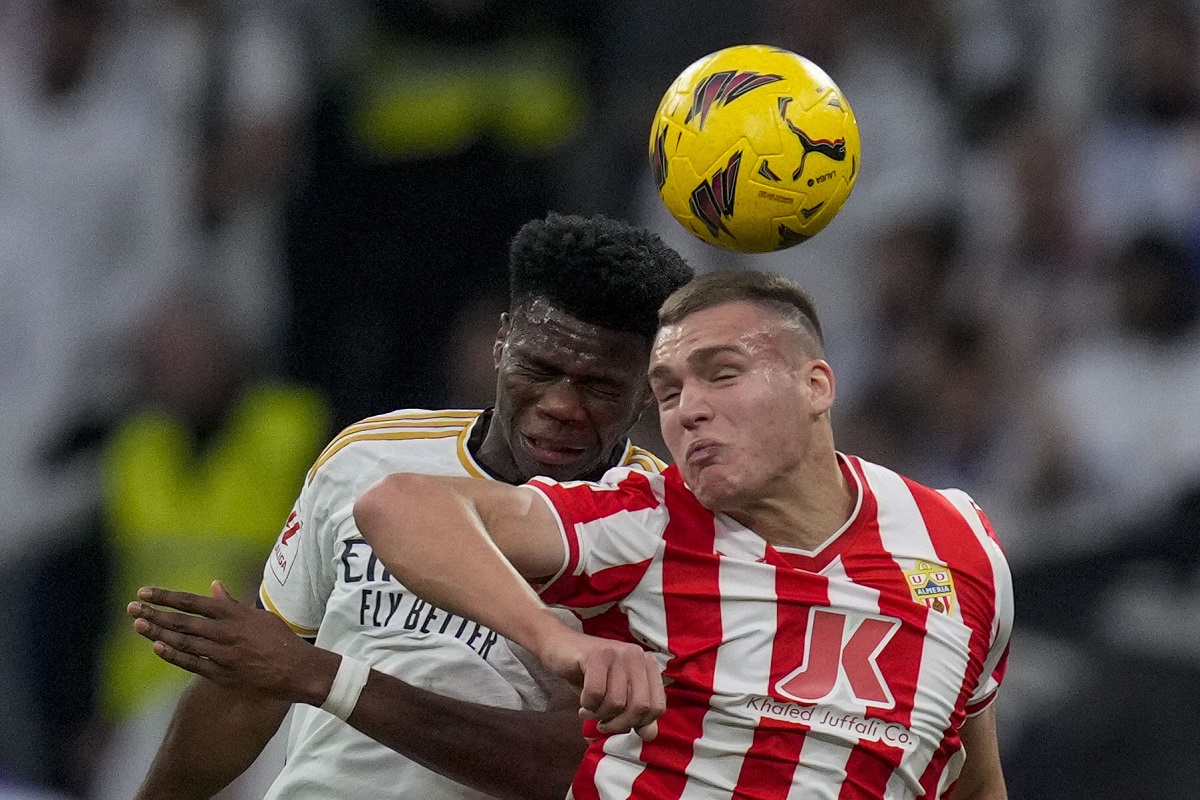 Almeria's Marko Milovanovic, right, jumps for the ball with Real Madrid's Aurelien Tchouameni during a Spanish La Liga soccer match between Real Madrid and Almeria at the Santiago Bernabeu stadium in Madrid, Spain, Sunday, Jan. 21, 2024. (AP Photo/Bernat Armangue )