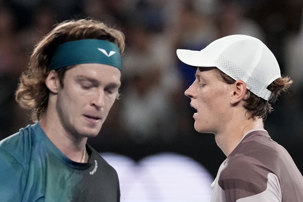 Jannik Sinner, right, of Italy and Andrey Rublev of Russia cross at a change of ends during their quarterfinal match at the Australian Open tennis championships at Melbourne Park, Melbourne, Australia, Wednesday, Jan. 24, 2024. (AP Photo/Alessandra Tarantino)