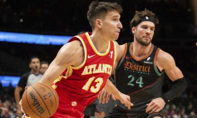 Atlanta Hawks guard Bogdan Bogdanovic (13) dribbles past Washington Wizards forward Corey Kispert (24) during the second half of an NBA basketball game Saturday, Jan 13, 2024, in Atlanta. (AP Photo/Hakim Wright Sr.)