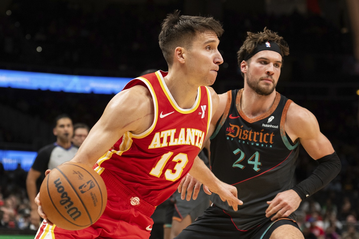 Atlanta Hawks guard Bogdan Bogdanovic (13) dribbles past Washington Wizards forward Corey Kispert (24) during the second half of an NBA basketball game Saturday, Jan 13, 2024, in Atlanta. (AP Photo/Hakim Wright Sr.)