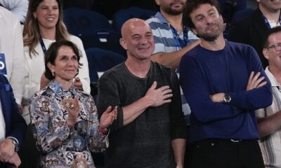 Former Australian Open champion Andre Agassi, centre, reacts as Serbia's Novak Djokovic speaks following his first round win over Croatia's Dino Prizmic at the Australian Open tennis championships at Melbourne Park, Melbourne, Australia, Sunday, Jan. 14, 2024. (AP Photo/Alessandra Tarantino)