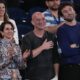 Former Australian Open champion Andre Agassi, centre, reacts as Serbia's Novak Djokovic speaks following his first round win over Croatia's Dino Prizmic at the Australian Open tennis championships at Melbourne Park, Melbourne, Australia, Sunday, Jan. 14, 2024. (AP Photo/Alessandra Tarantino)