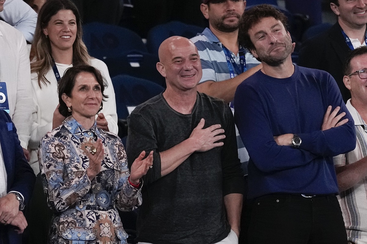 Former Australian Open champion Andre Agassi, centre, reacts as Serbia's Novak Djokovic speaks following his first round win over Croatia's Dino Prizmic at the Australian Open tennis championships at Melbourne Park, Melbourne, Australia, Sunday, Jan. 14, 2024. (AP Photo/Alessandra Tarantino)