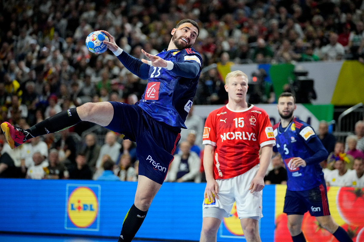 France's Ludovic Fabregas, left, throws the ball against Denmark's Magnus Saugstrup during the Handball European Championship final match between France and Denmark in Cologne, Germany, Sunday, Jan. 28, 2024. (AP Photo/Martin Meissner)