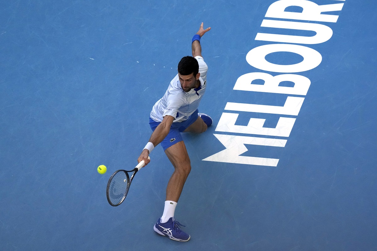 Novak Djokovic of Serbia plays a backhand return to Taylor Fritz of the U.S. during their quarterfinal match at the Australian Open tennis championships at Melbourne Park, Melbourne, Australia, Tuesday, Jan. 23, 2024. (AP Photo/Alessandra Tarantino)