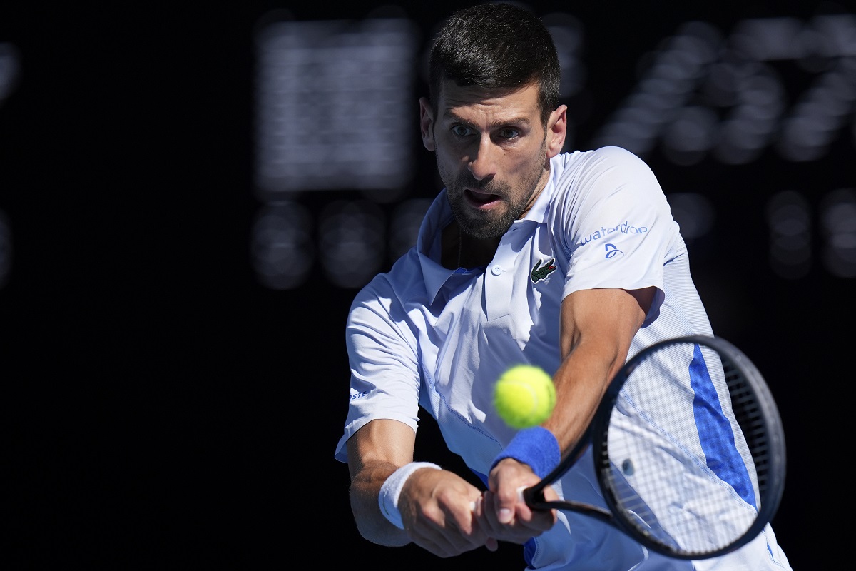 Novak Đoković of Serbia plays a backhand return to Taylor Fritz of the U.S. during their quarterfinal match at the Australian Open tennis championships at Melbourne Park, Melbourne, Australia, Tuesday, Jan. 23, 2024. (AP Photo/Andy Wong)